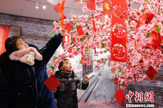 孩子们在许愿树下写下新年祝福。 殷立勤 摄